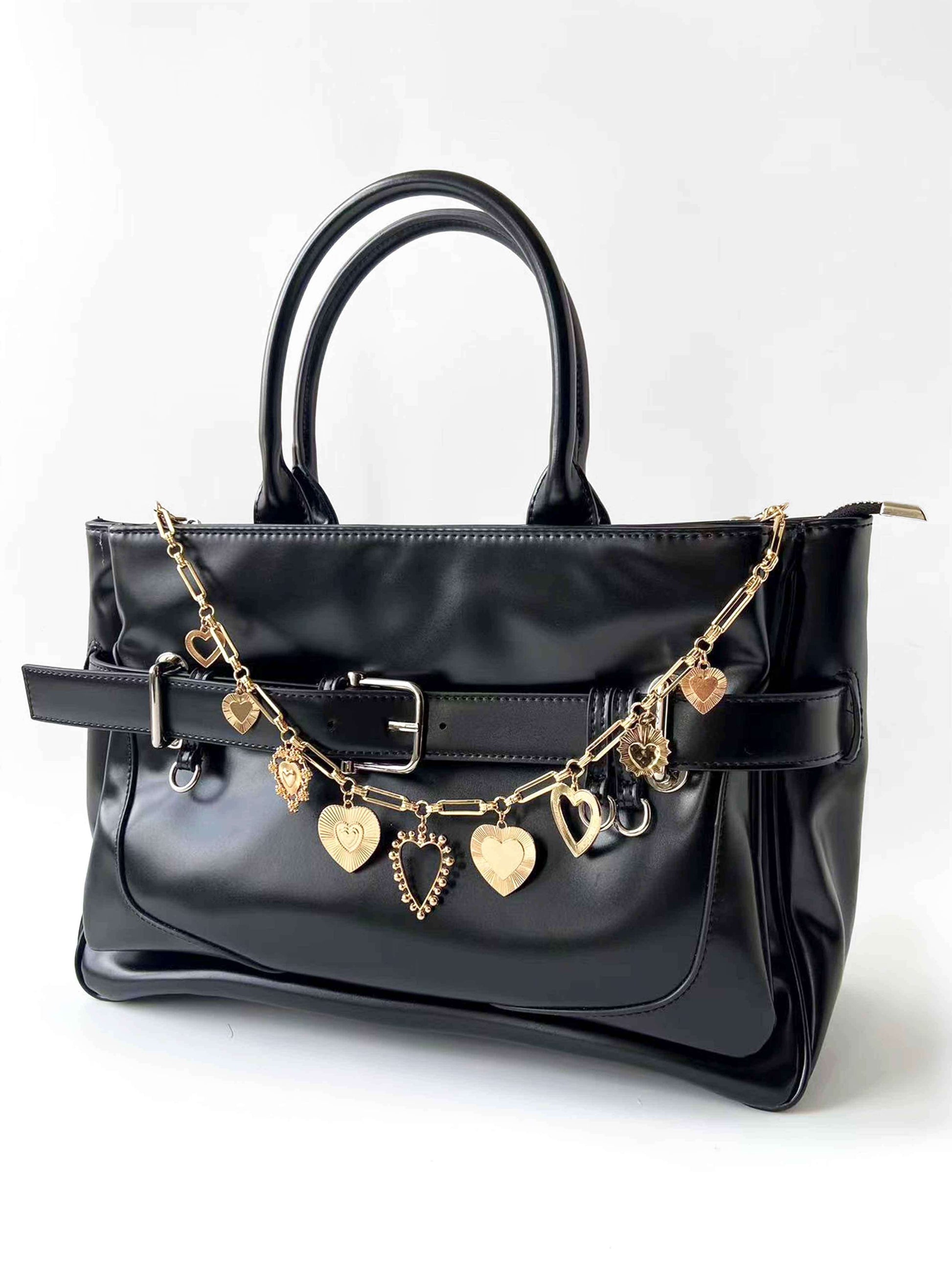 Golden heart pendant chain decorates black bag, stylish and exquisite.