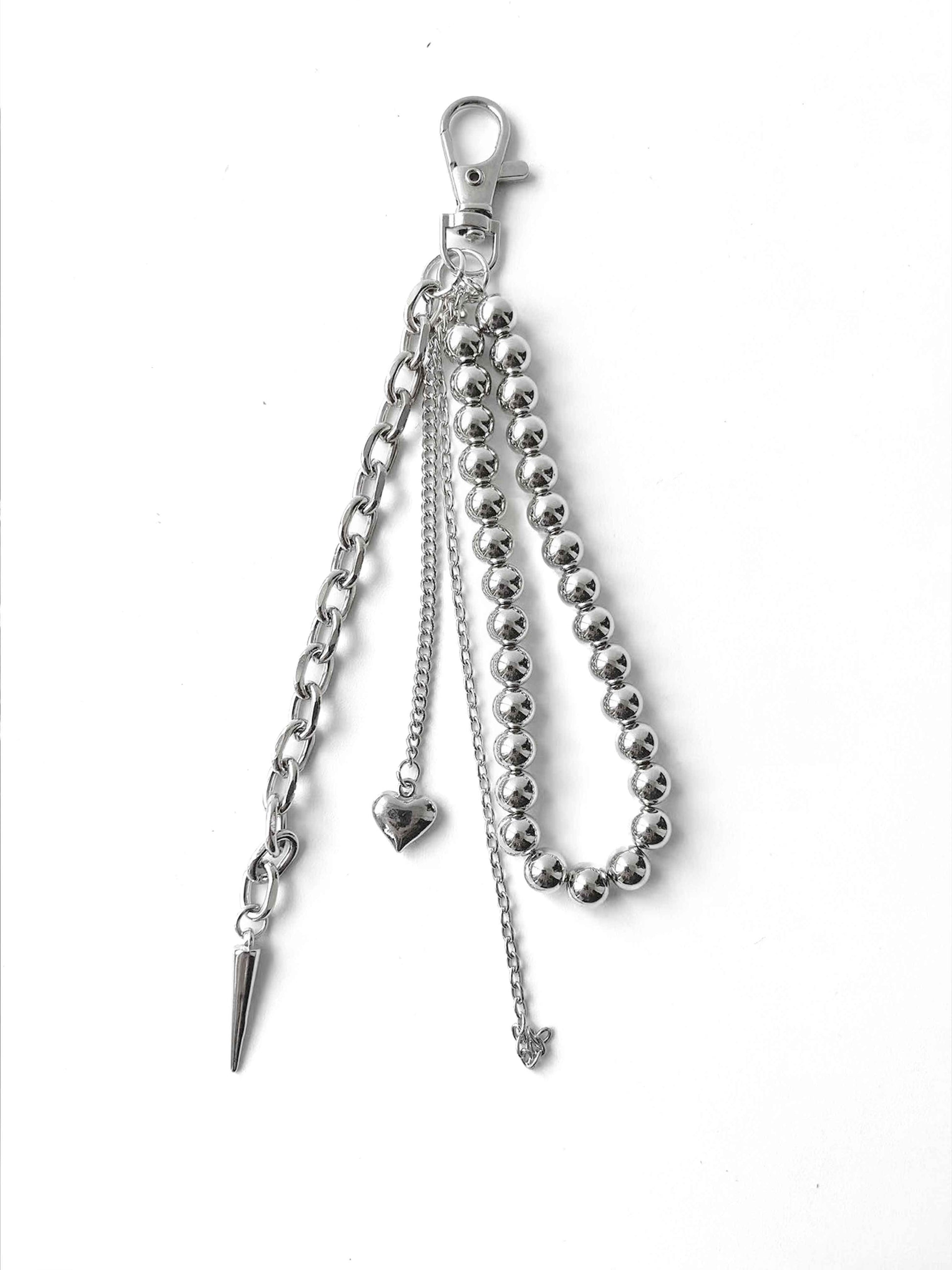 Integrated multi-layer metal chain decoration with heart, spike, and butterfly pendants, adding edgy details to the bag.