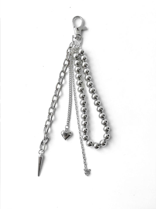 Integrated multi-layer metal chain decoration with heart, spike, and butterfly pendants, adding edgy details to the bag.
