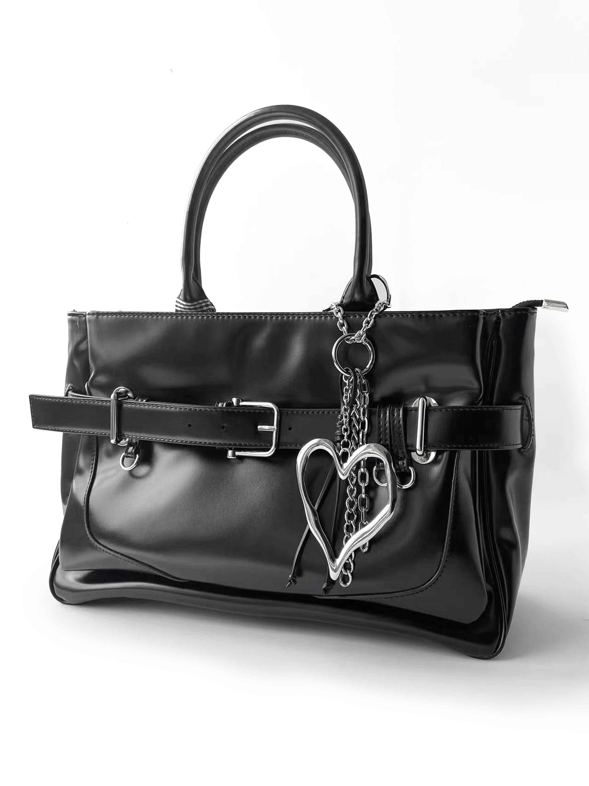 Black shiny handbag with heart-shaped chain ornament, fashionable and textured style.